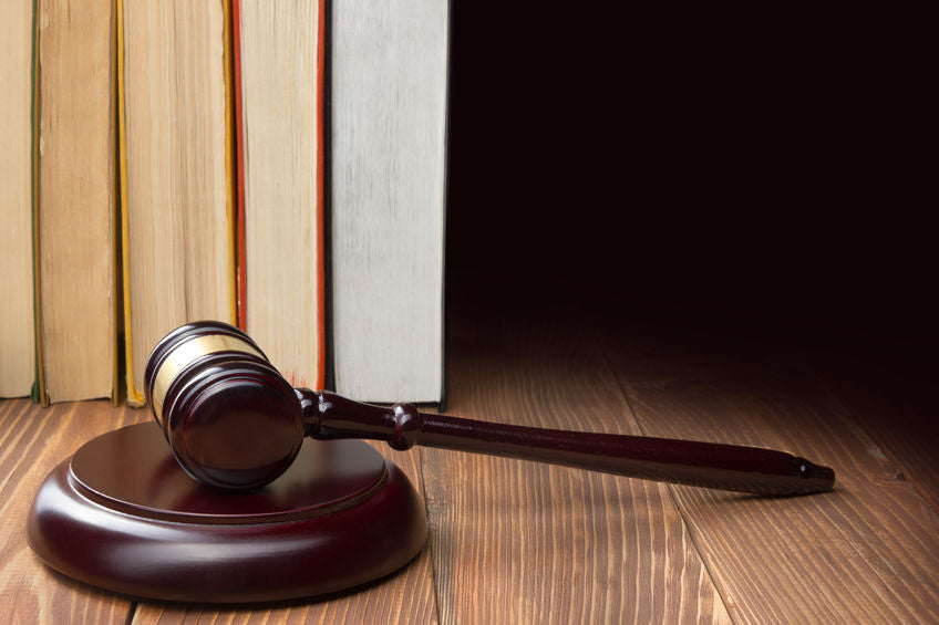 Law books with a wooden judges gavel on a wooden table