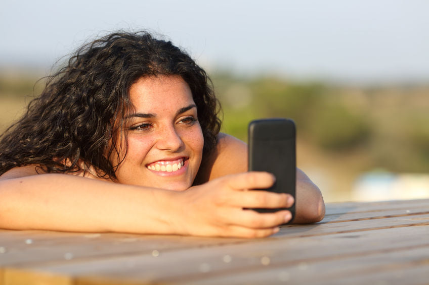 girl watching social media in smart phone relaxing in a park