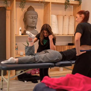 UK massage therapist professional leg stretching on the Advantage liftback table highlighting its 450lb working weight and stable frame.