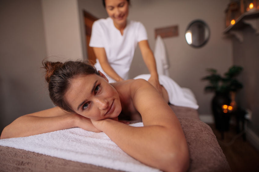 close up of a young woman receiving a massage from a female massage therapist