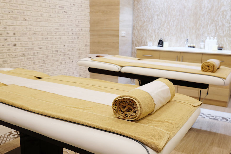 Two empty massage tables in a spa