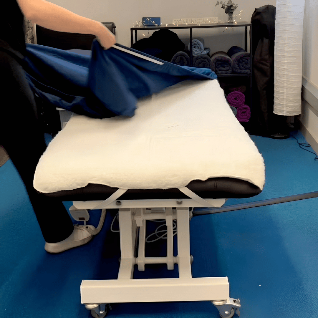 Close-up view of the machine washable fleece pad set with headrest cover for massage couch, ideal for holistic therapists, spa technicians, and clinical massage specialists wanting to order fleece massage table pad set online UK from Massage Warehouse in Manchester; includes a 30" x 74" (75 cm x 186 cm) body pad and matching headrest fleece cover anchored by universal elastic straps to add winter warmth and extra cushioning under fitted sheets.